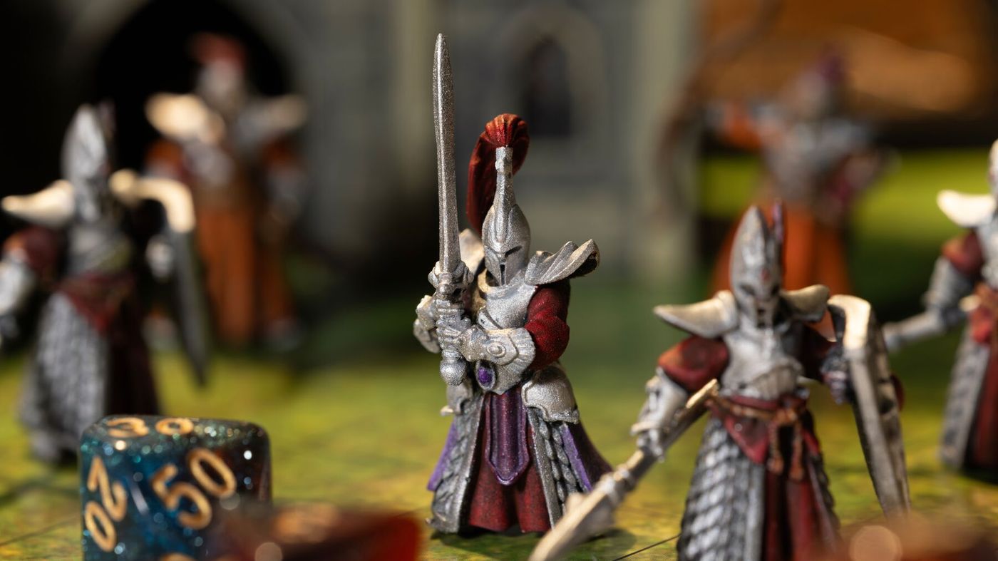 Painted printed knight figures with dice on a game board