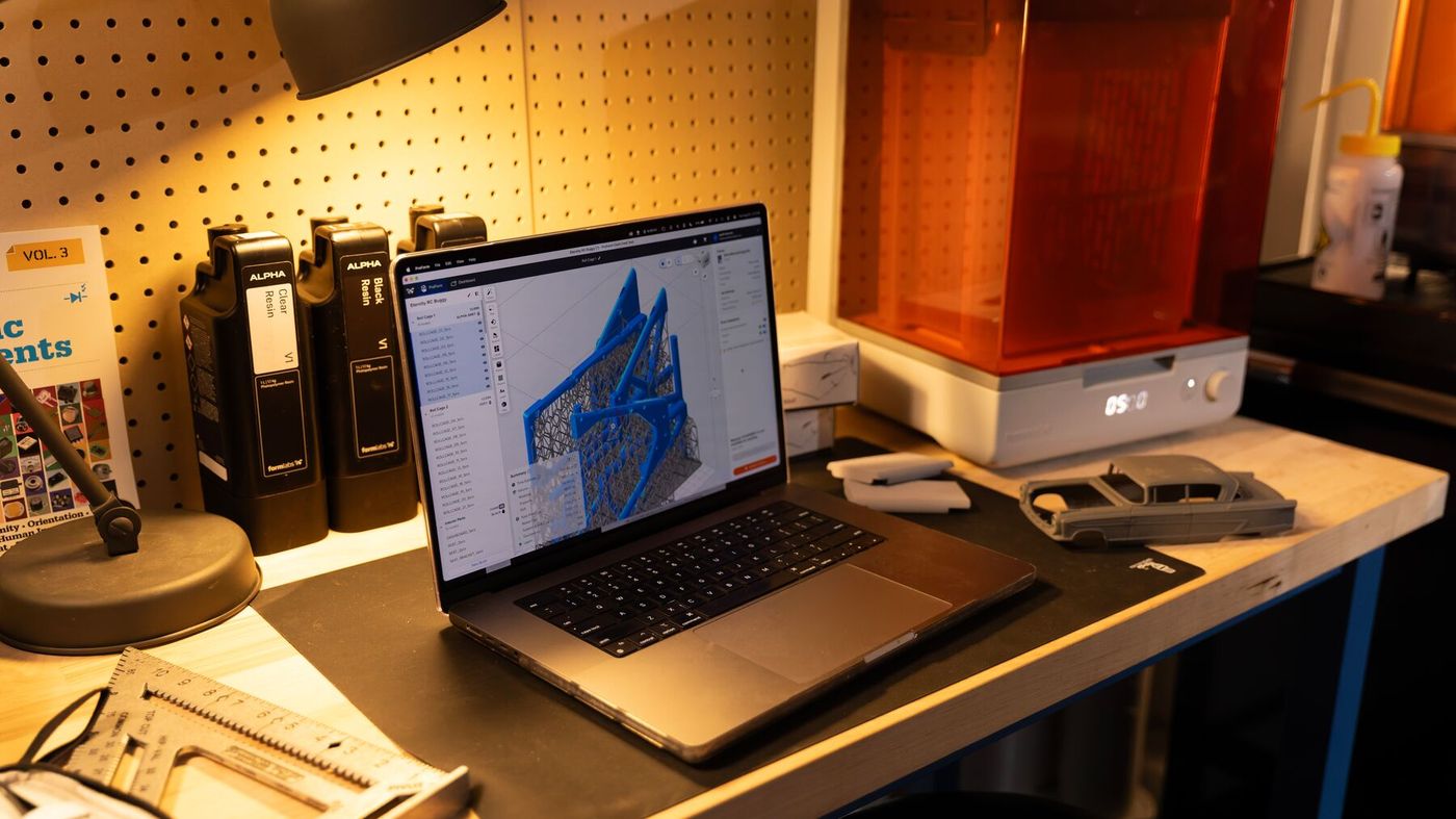 PreForm print preparation software open on a laptop beside the printer