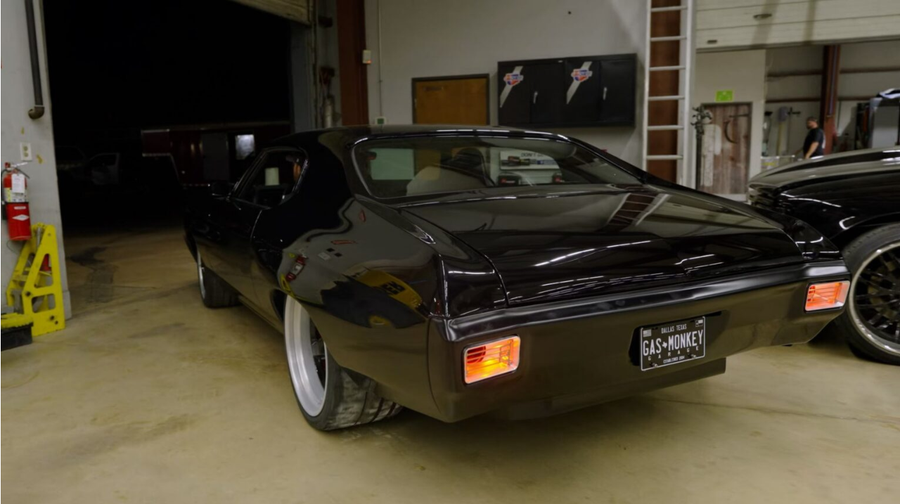 Black classic muscle car parked in a garage