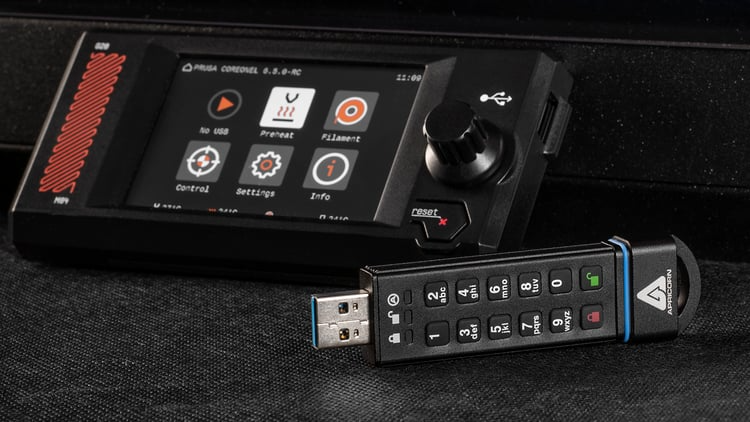 A secure USB drive is positioned next to the Prusa CORE One L touch screen to highlight offline capabilities crucial to secure printing operations.