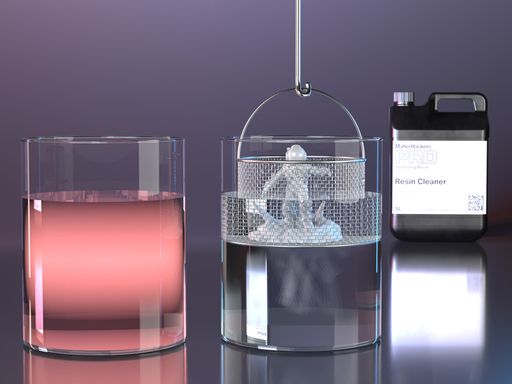 Washed resin miniature in a mesh basket being lowered into a glass of clean water