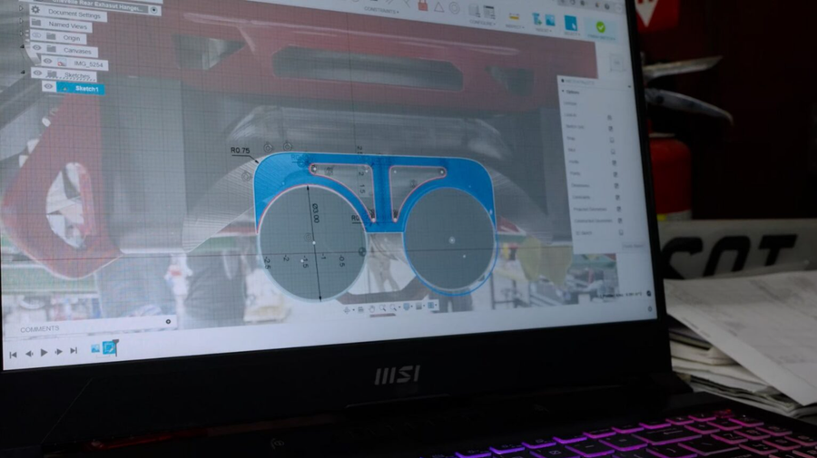 CAD sketch of a glasses frame design on a laptop screen