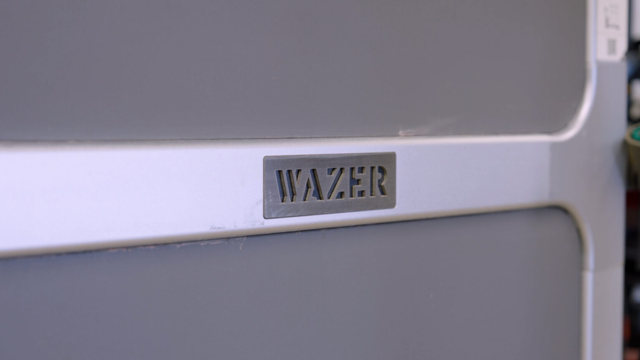 WAZER logo badge on a desktop waterjet cutter