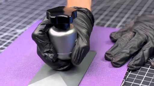 A gloved hand presses a build plate flat against sandpaper