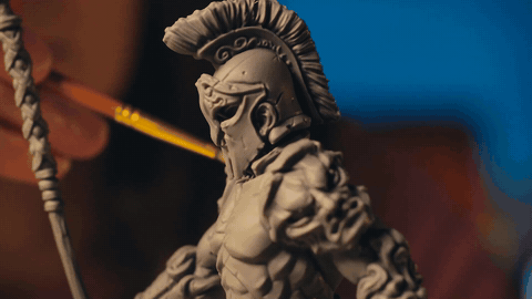 A brush paints fine detail on a resin-printed Spartan bust